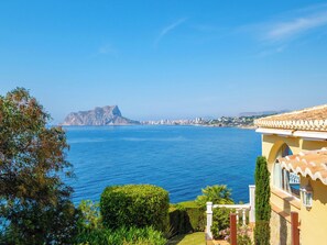 A coastal view with a mountain, clear blue sea, and a building with a balcony. - Horizonte by Interhome (Benissa)