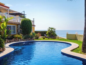 A swimming pool with a curved edge, a lounge chair, a well-maintained lawn, and a view of the ocean. - Horizonte by Interhome (Benissa)