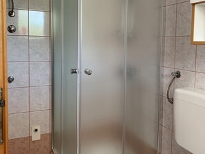 Ein Badezimmer mit Duschkabine, Waschbecken und Toilette.