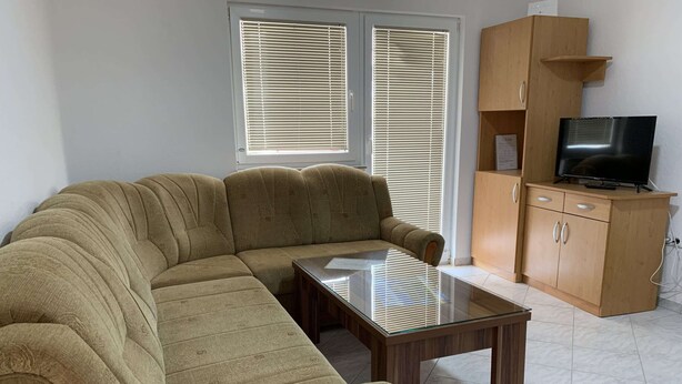 A living room with a sofa, a glass coffee table, a wooden cabinet, and a television. - Apartment Vir 1 (Vir)