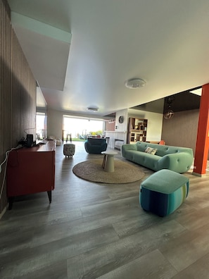 Ein modernes Wohnzimmer mit einer Couch, einem Hocker und einem runden Couchtisch.