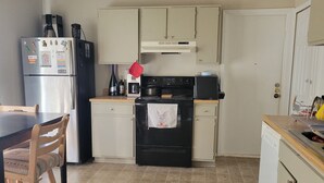 A kitchen with a refrigerator, stove, oven, and a coffee maker. - Wonderful 3-bedroom house with AC in charming San Antonio (San Antonio)