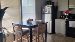 A kitchen with a dining table, chairs, a refrigerator, and a microwave. - Wonderful 3-bedroom house with AC in charming San Antonio (San Antonio)