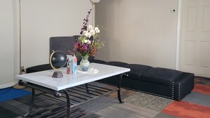 A room with a white table, a black sofa, a globe, a vase with flowers, and a lamp. - Wonderful 3-bedroom house with AC in charming San Antonio (San Antonio)