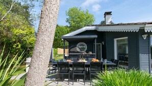 A house with a patio area, outdoor seating, and a grill. - Villa Alaïa - Hossegor - Cycle path - Shops (Soorts-Hossegor)