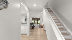 Ein modernes Interieur mit Treppe, Essbereich und Küche.
