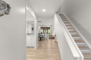 Ein modernes Interieur mit Treppe, Essbereich und Küche.
