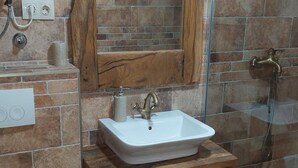 A bathroom with a white sink, wooden vanity, and a glass shower enclosure. - Villa Nicoletta (Polaca)