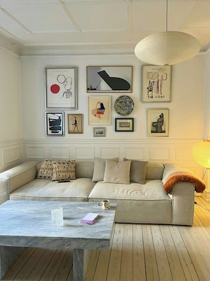 Ein Wohnzimmer mit einer Couch, einem Couchtisch und Wandbildern.