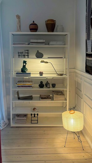 Ein weißes Bücherregal mit verschiedenen Dekorationselementen und Büchern.