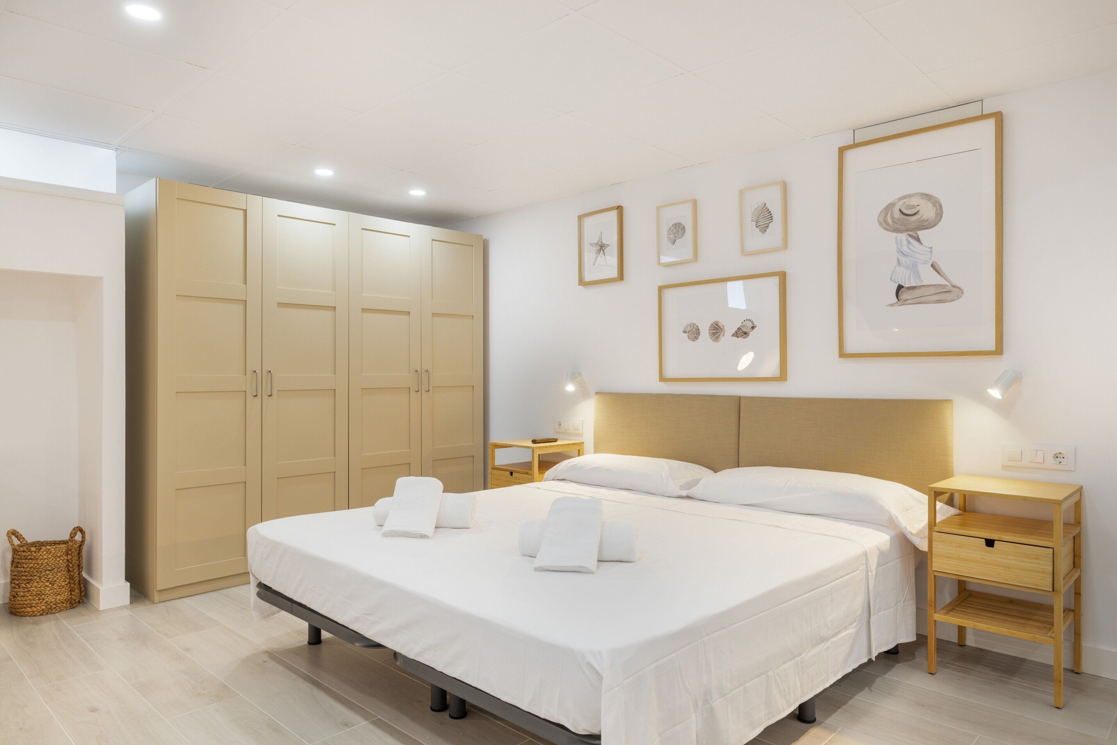 Una camera da letto con un letto, comodini, un armadio e decorazioni alle pareti.
