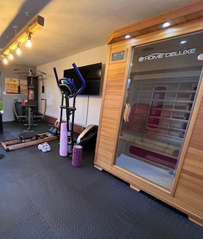 A home gym with exercise equipment, a treadmill, a stationary bike, and a massage chair.