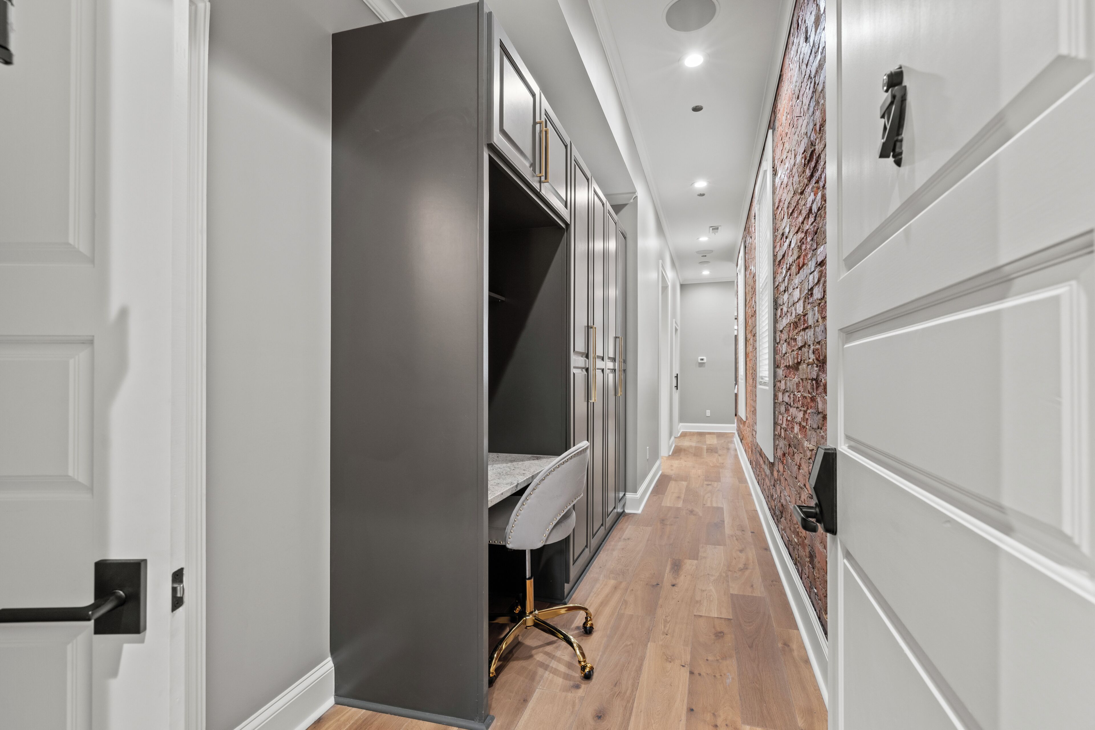 A hallway with a wardrobe, a desk, and a chair.