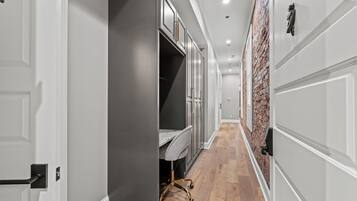 A hallway with a wardrobe, a desk, and a chair.