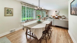 Un comedor con una mesa dispuesta para cuatro personas, un candelabro y un sofá al fondo.