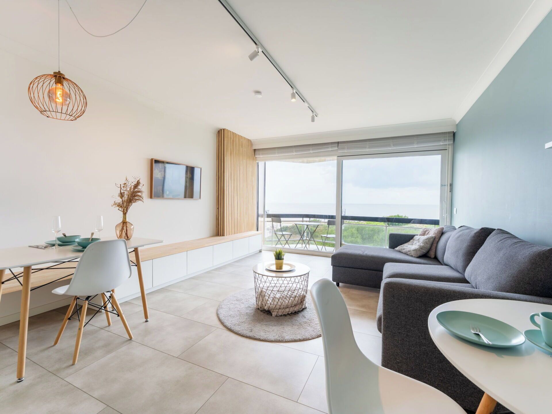 Ein modernes Wohnzimmer mit Essbereich, großen Fenstern und Blick ins Freie.
