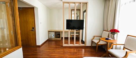 Habitación de hotel con dos camas, un televisor, un escritorio y una silla.