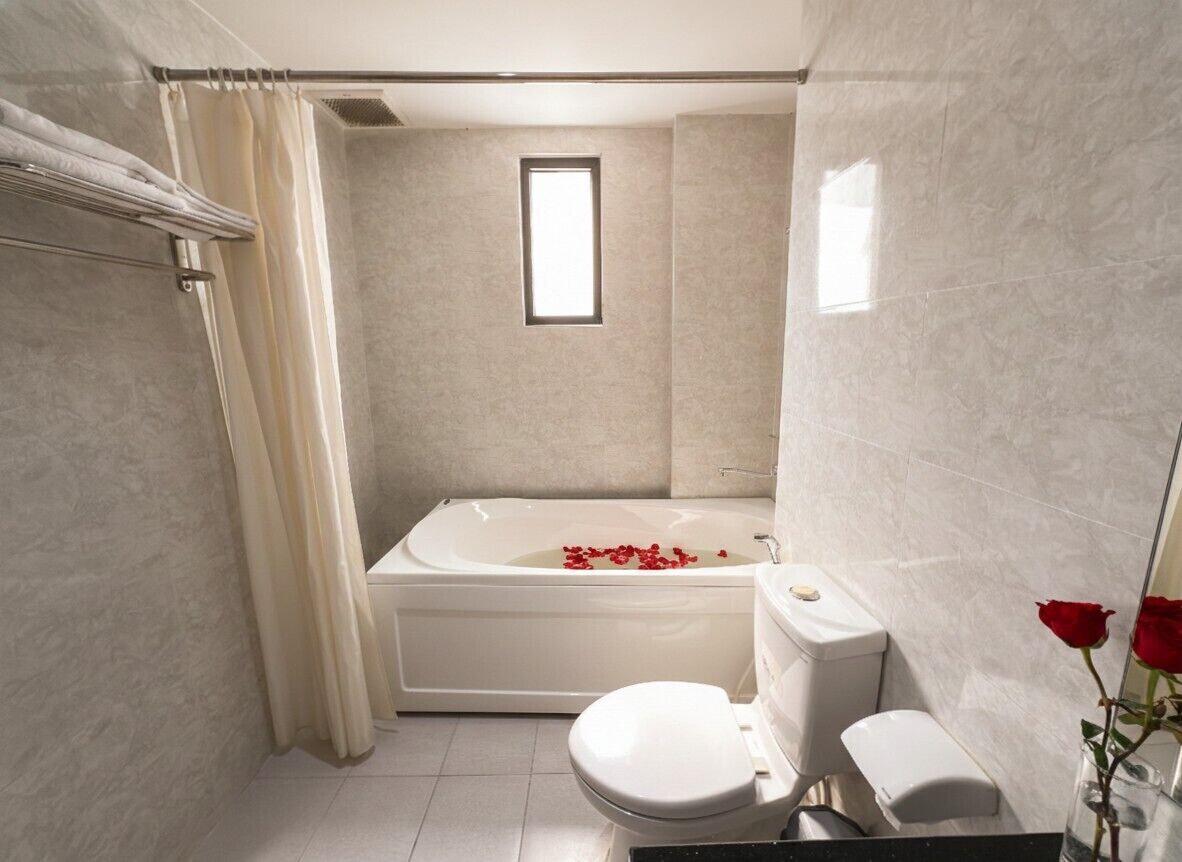 Un baño con bañera, inodoro y ventana.