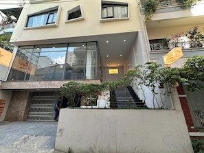 Un edificio moderno con ventanas amplias, una escalera y un letrero que dice 'Zesty'.