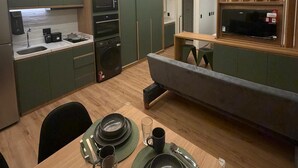 Une cuisine moderne avec des meubles de couleur verte, un four à micro-ondes et un four encastré.