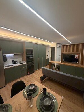 A modern kitchen with green cabinets, a microwave, and a built-in oven. - Green Loft - Wonderful City (Rio de Janeiro)