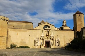 A historic building with a central entrance, a bell tower, and a fortified wall. - Apartment 'Rural Ca La Roser' with Private Terrace, Wi-Fi and Air Conditioning (L'Espluga de Francolí)