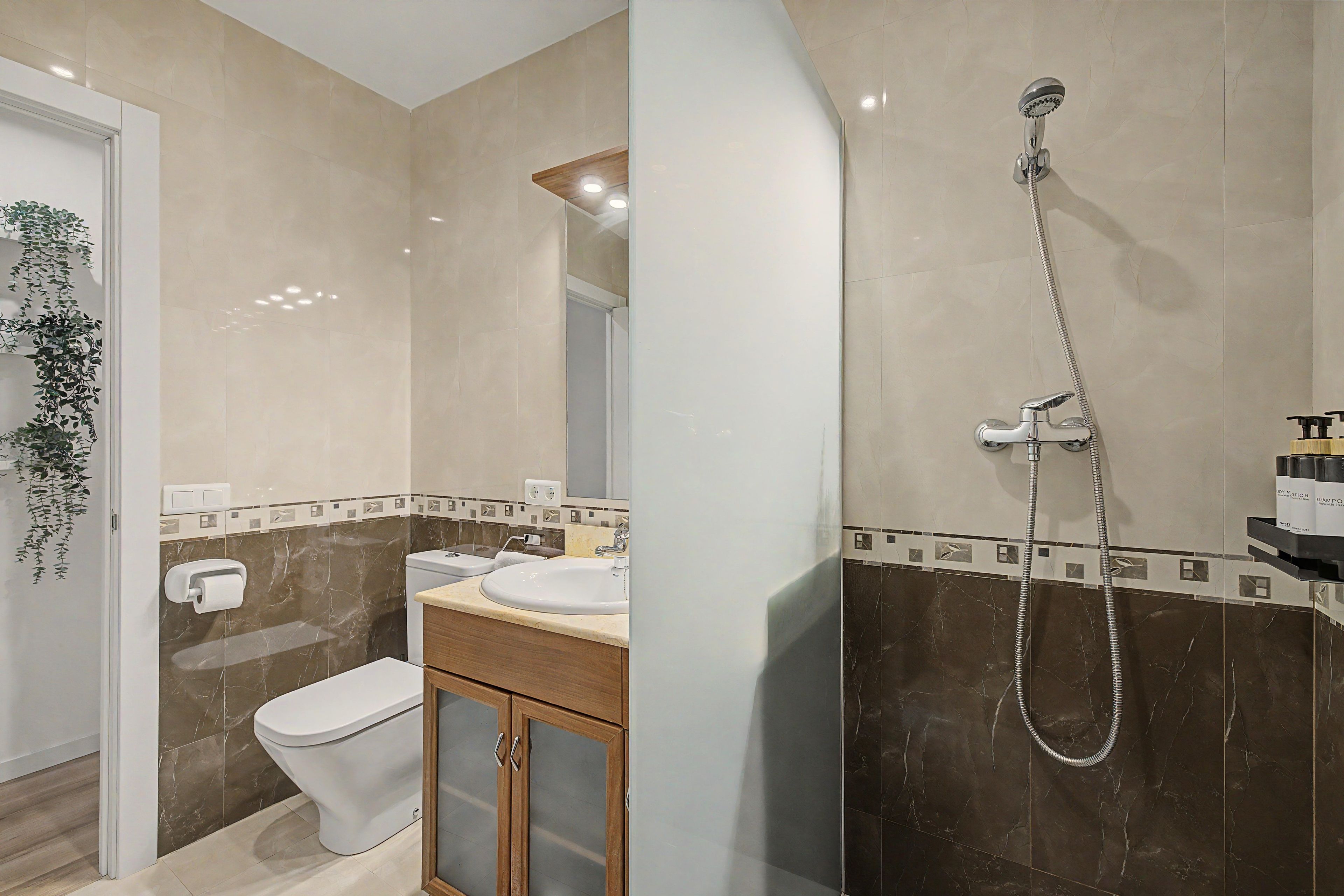 A bathroom with a toilet, sink, and shower.