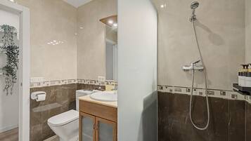 A bathroom with a toilet, sink, and shower.