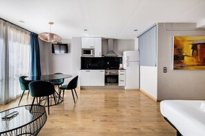 Una cocina moderna con armarios blancos, microondas, estufa y refrigerador.