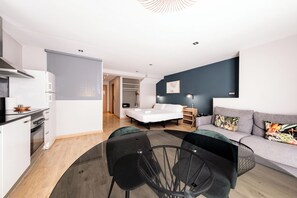 A compact living space with a kitchenette, a bed, a sofa, and a dining area. - Sicilia-1602 - Studio Apartment, Sleeps 2 (Barcelona)