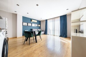 Ein modernes Wohnzimmer mit Essbereich, einer Couch und einer Küchenzeile.