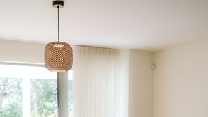 Una sala de estar moderna con un sofá, una mesa de centro, una silla y un cojín rojo.