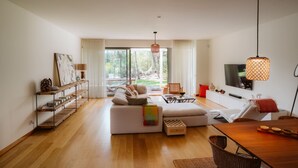 Una sala de estar moderna con un sofá, una mesa de comedor y un televisor.