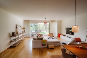 Una sala de estar moderna con un sofá, una mesa de comedor y un televisor.