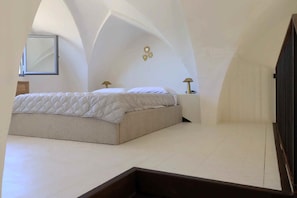A bedroom with a bed, two bedside lamps, a mirror, and a wall with heart-shaped decorations. - Riad del Capo by LoveSud (Castrignano del capo)