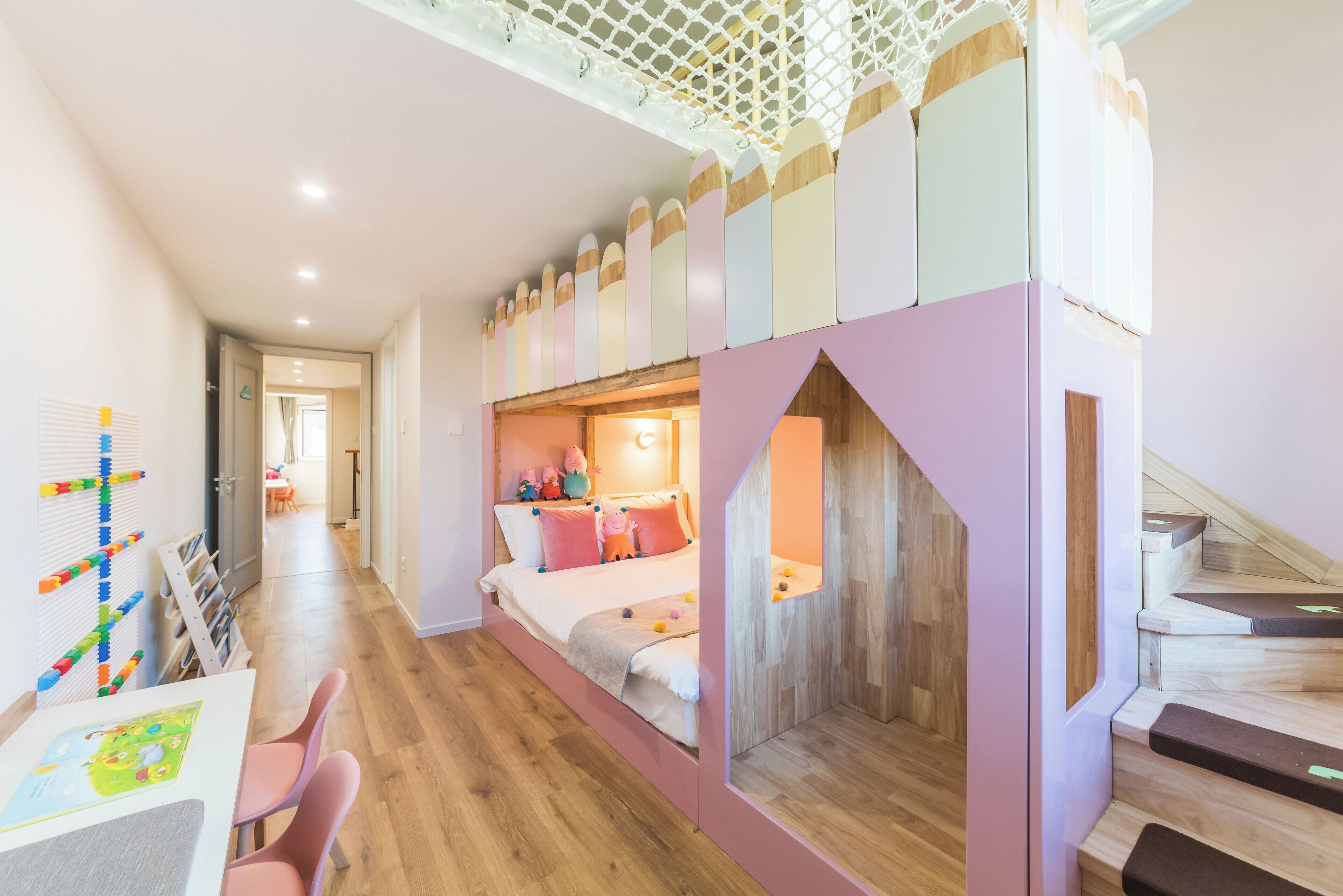 A child's bedroom with a bunk bed, a play area with toys, and a staircase.