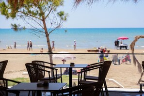 Un restaurant situé en bord de mer, avec une terrasse offrant une vue sur l’océan.