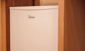 Ein weißes Midea-Gerät in einem Holzkabinent.