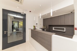 A modern kitchen with a dark wood countertop, a glass door, and a view of the outdoors. - Altiora Prestige Residence 303 (Gradac)