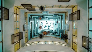 Una escalera de caracol con un atrio central, rodeada de paredes con diseños y barandillas de metal.