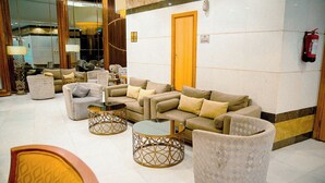 Un vestíbulo con sofás, sillones y una mesa de centro.