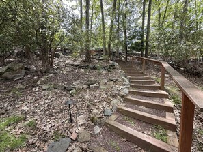 A wooden staircase in a forested area with natural surroundings.