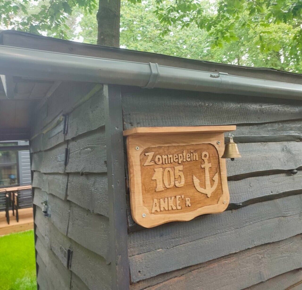 A wooden sign with the number 105 and the name 'Zonneplein' on a building.