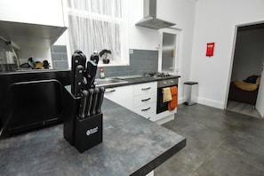 Eine moderne Küche mit Gasherd, Spüle und Messerblock.