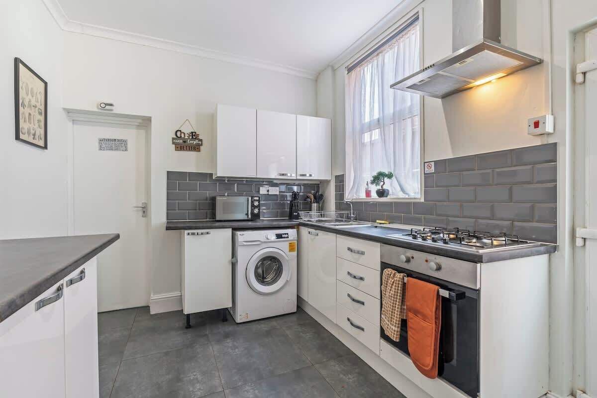 Eine moderne Küche mit eingebauter Waschmaschine, Backofen und Mikrowelle.