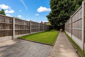 A fenced backyard with a paved pathway and a grassy area. - Spacious 4BDR | Ideal for Contractors |City centre (Coventry)