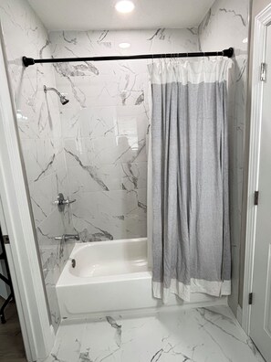 A bathroom with a shower, a bathtub, and a marble wall. - Mins from Duke Hospital and UNC Chapel Hill (Durham)