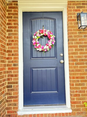A dark blue door with a wreath, a keyhole, and a small wall-mounted light fixture. - Mins from Duke Hospital and UNC Chapel Hill (Durham)