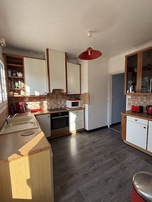 A compact kitchen with a microwave, oven, and wooden cabinets.
