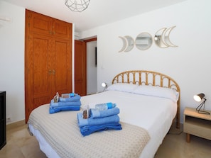 A bedroom with a bed, wooden wardrobe, wall-mounted mirrors, and a bedside table with a lamp. - Alcazar by Interhome (Almuñécar)